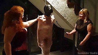 Cling wrapped slave receives CBT from dominatrix duo