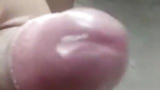 Stroking shiny cock with precum