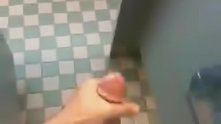 A nasty dude jerks his dick off in the public bathroom