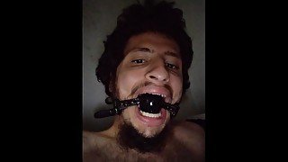 Gagged boy spitting in himself while wanking his big cock