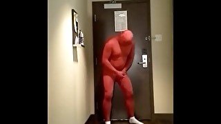 red morphsuit jerking off at hotel room door