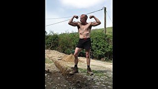 Fit shirtless muscular construction worker flexes biceps and jerks off working outdoors