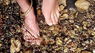 Walking barefoot in the river. Hairy legs. Ankles jewelery.