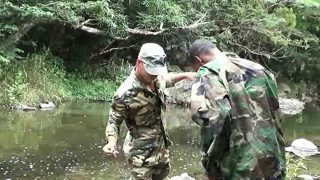 Two military lads resting by the river