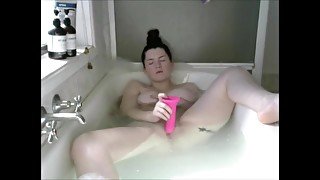 Busty brunette babe fucking herself in the bathtub