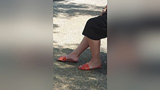 Candid Legs And Feet In Orange Sandals Of A Brunette Woman At The Bus