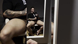 Gay bodybuilder sitting and stroking his massive GAY dick slowly