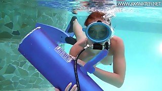 Scuba diving girl in a pool sucks on a dildo