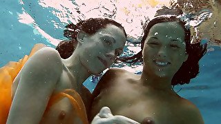 Cute and happy European girls swimming in the pool