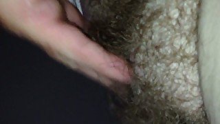 Stroking her hairy pussy.