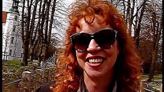 Redhead lady wearing sunglasses while giving an interview