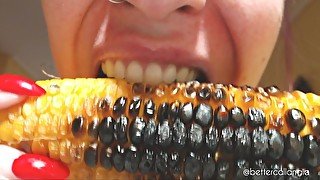 I bite and chew a delicious roasted corncob, a close-up of my sharp teeth