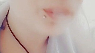 Girl with piercings smokes a cigarette