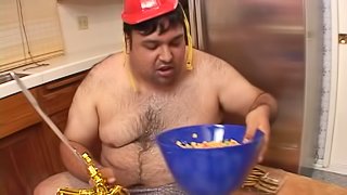 Chubby guy eating while fucking a sexy brunette in his kitchen