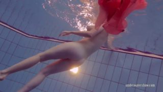 Redhead girl privsem in red silk dress shows nude body underwater