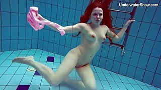 Redhead in a bodysuit goes for a sexy swim