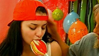 Lustful cute brunette teens switch from sucking a lollipop to giving a blowjob