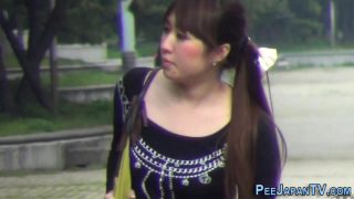 High heeled asian ho pees on road