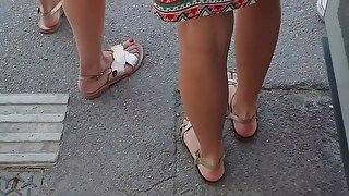 Beautiful Legs And Feet In Sandals Of Two Attractive Young Women