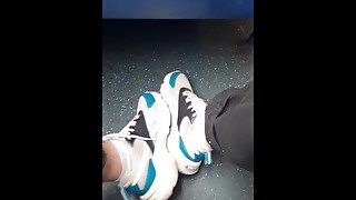 guy in jeans shows off his sneakers and white socks on the train