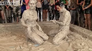 Leather-clad brunette with a sexy body having a catfight in a mudbath