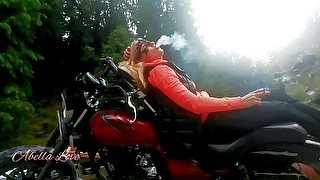 Red lips blonde smoking sensually on Rasta bike outdoor