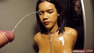 Thai tranny Jessie wears only handcuffs, collar with leash and penis cage.