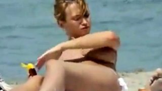 Oiling boobs on topless beach