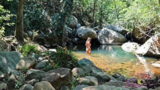 VOYEUR ON A GIRL BATHING IN A SUNNY STREAM