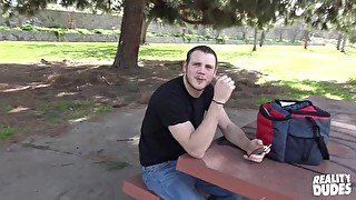 Gay college student Levi takes of his shirt in a park and sucks dick