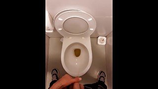 young guy pissing in a public toilet