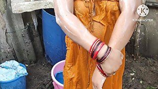 Indian house wife bathing outside with