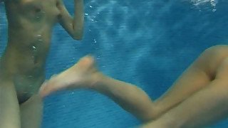 Two funky naked teens play with rubber sex dolls in swimming pool