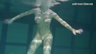 Naked brunette with big tits swims solo