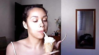 Kinky brunette with really long weird nails is eating ice cream