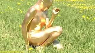 ebony babe in skintight golden spandex catsuit posing outdoor