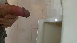 Pissing with a big dick with big balls in a public toilet in a urinal