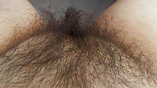 Stroking long black pussy hair alone in bed