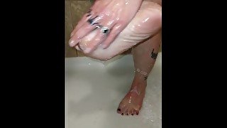 Milf washes feet in the shower