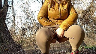 MILF with big butt covered in leggings gives a plentiful golden shower outdoors.