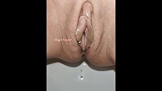 Golden drops fall from a smoothly shaved pussy. Slow motion