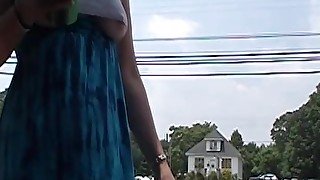 MILF braless wearing a cut off crop top revealing underboob near roadside with traffic