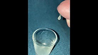 Closeup dripping cum in shot glass slo-mo