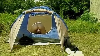 Camping girl is all alone in her tent and playing with a toy