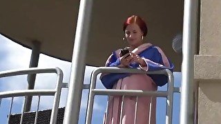 Redhead pees over her balcony in the city