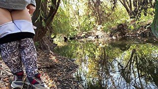 MILF dressed in leggings pissing in the river