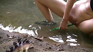 Willamina plays with dinosaurs toys at the creek