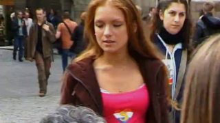 Cute redhead walks along the streets of prague