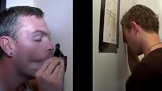 Busty gay with studs giving his gentleman blowjob through gloryhole