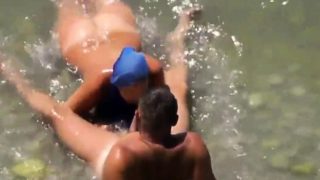 Girl sucks dick her boyfriend in the surf at a public beach